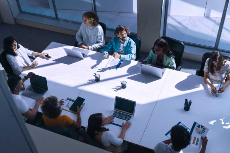 Group Of Young Diverse People In Smart Casual Wear Discussing Business While Sitting In The Creative Office Of A Modern Company