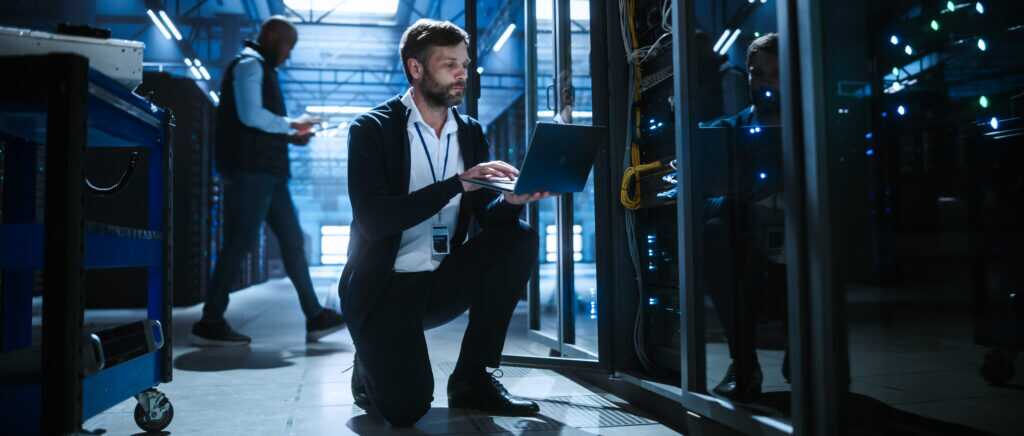 Technician Uses A Laptop Of Server Rack Systems In A Data Center