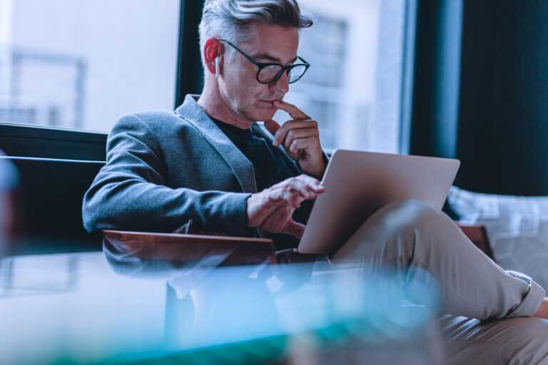 Businessman Reading Emails In Office Lobby