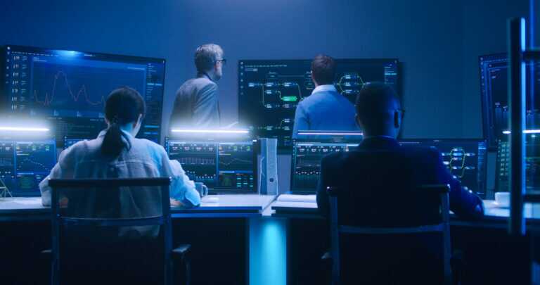 Team Of It Technical Specialists And Software Programmers Work In Monitoring Office