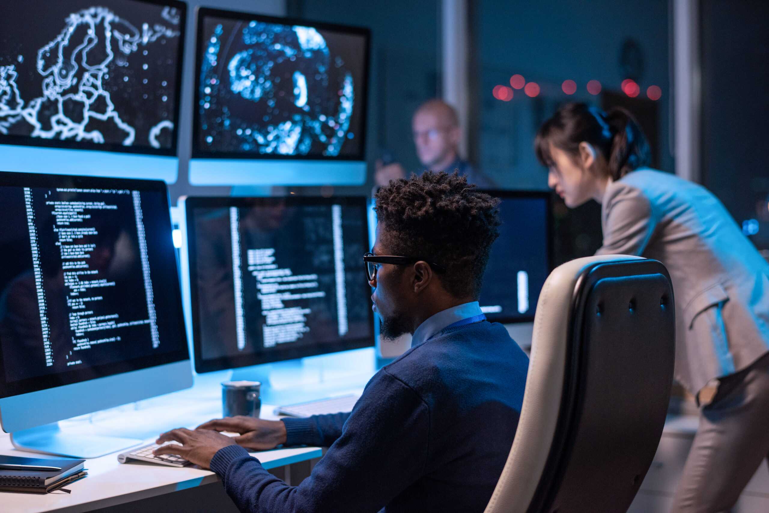 Young It Engineer Decoding Data While Sitting In Front Of Computers