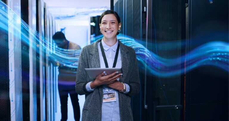Two IT professionals working inside a server room with racks of servers on both sides, with the SCC wave graphic in the background.