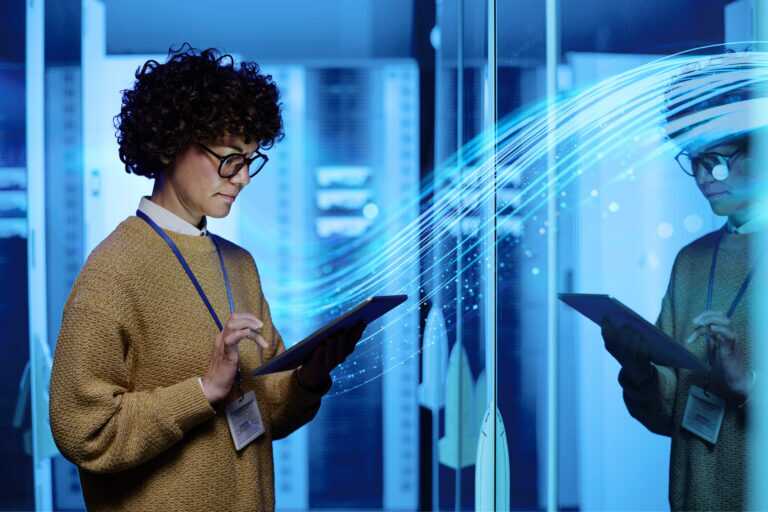 A person using a tablet in a server room, illustrating data flow and digital connectivity with the SCC wave graphic in the background.