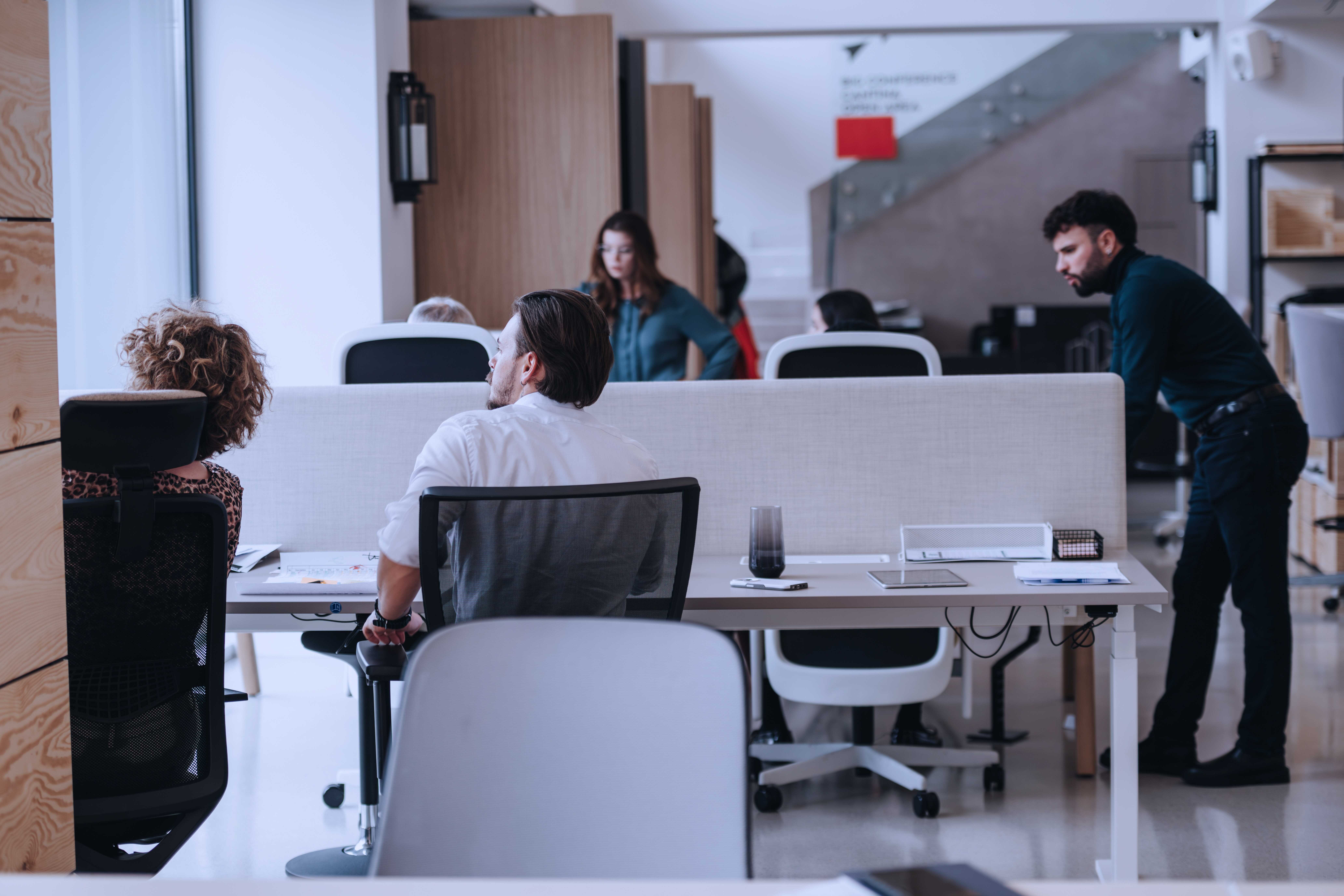Contemporary Office Space With Diverse Employees Engaging In Work Activities.