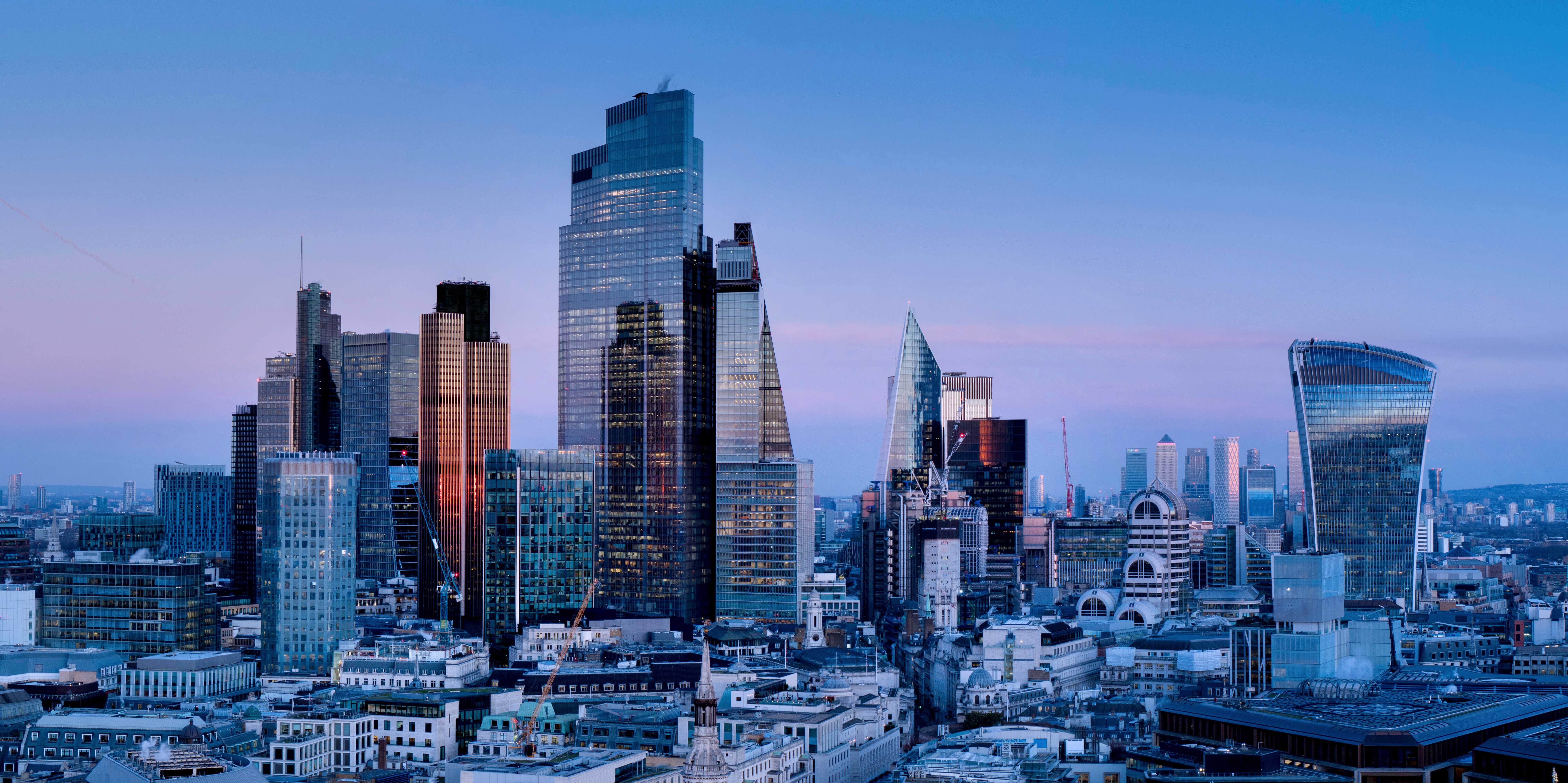 London skyline at dusk featuring prominent skyscrapers such as The Shard, 22 Bishopsgate, and the Walkie Talkie building.