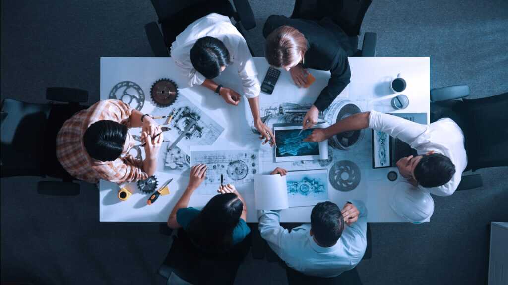Top View Of Smart Team Working Together To Design Turbine Engine. Alimentation.